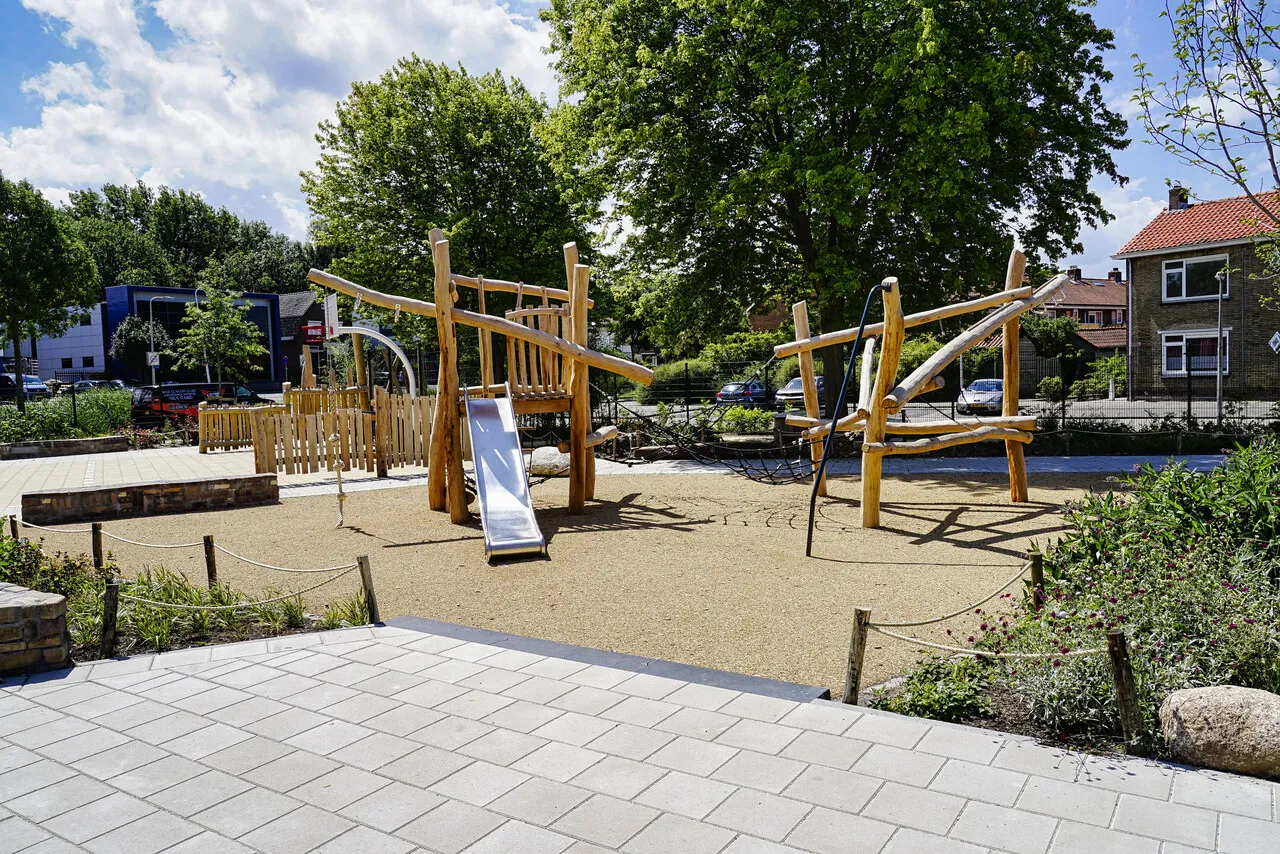 Vergroend schoolplein met speeltoestellen