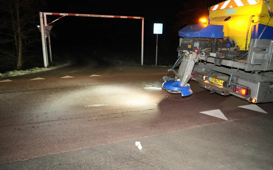 Strooiwagen strooit zout over een weg
